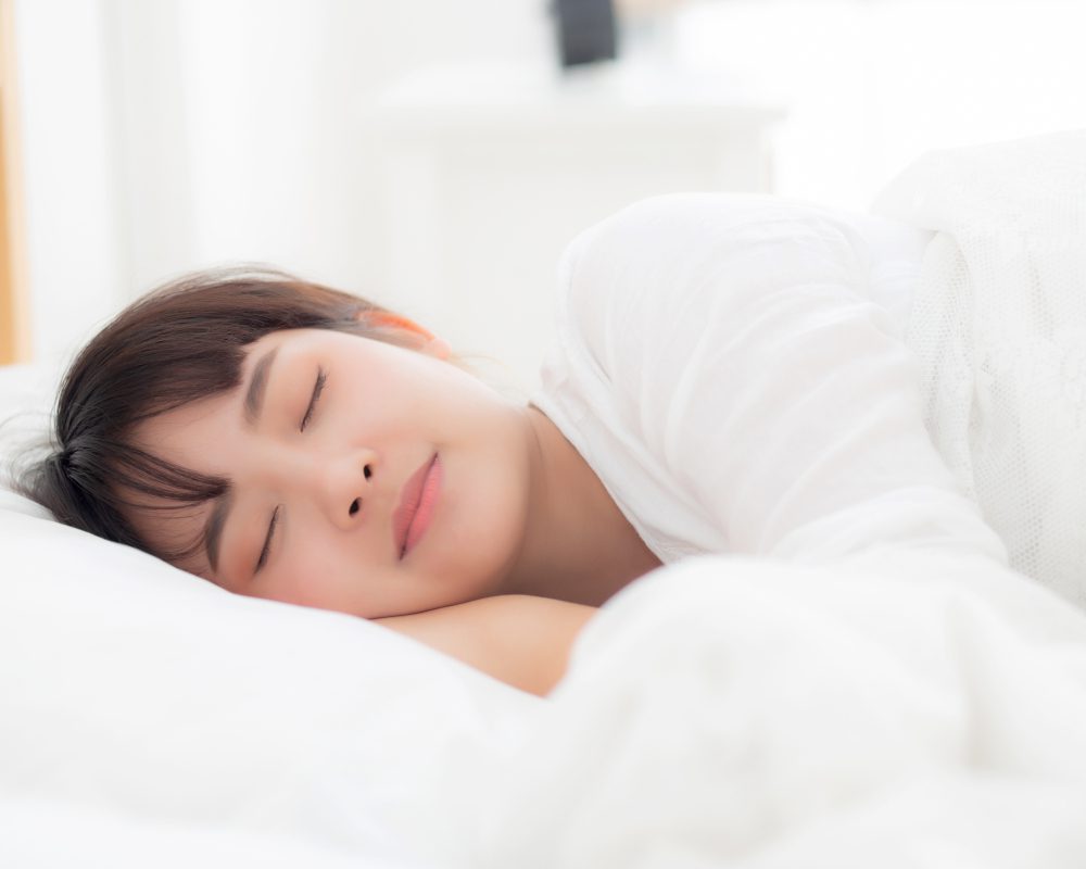 A person using a speaker pillow to rest comfortably.